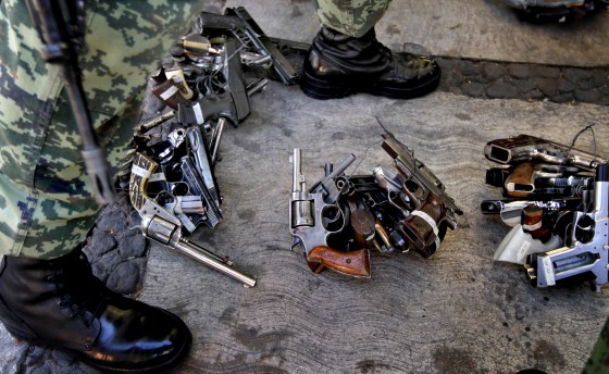 Image: A soldier stands near weapons given to the government in exchange for goods or money in Mexico City on Dec. 30, 2012.