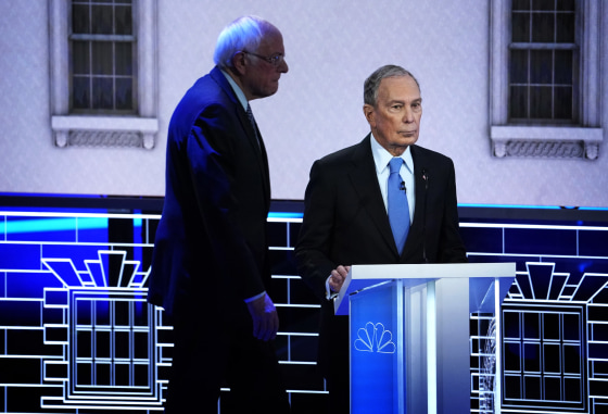 Image: Sen. Bernie Sanders walks behind Mike Bloomberg at a Democratic presidential primary debate in Las Vegas on Feb. 19, 2020.