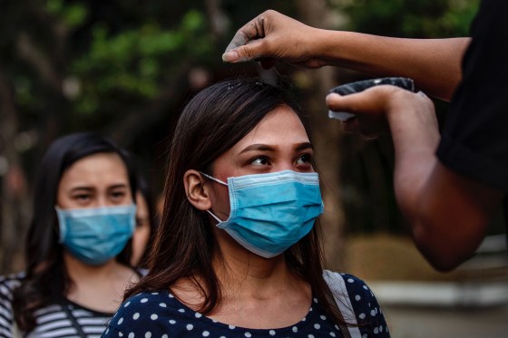 Image: Catholic devotees wearing protective masks fall in line to have their head sprinkled with ash during Ash Wednesday services at a church