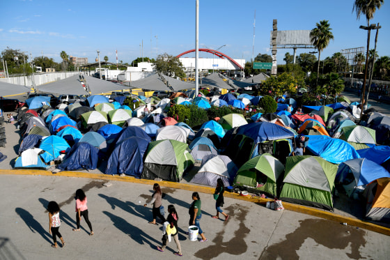 Image: FILE PHOTO: Migrants, most of them asylum seekers sent back to Mexico from the U.S. under the \"Remain in Mexico\" program officially named Migrant Protection Protocols (MPP), occupy a makeshift encampment in Matamoros