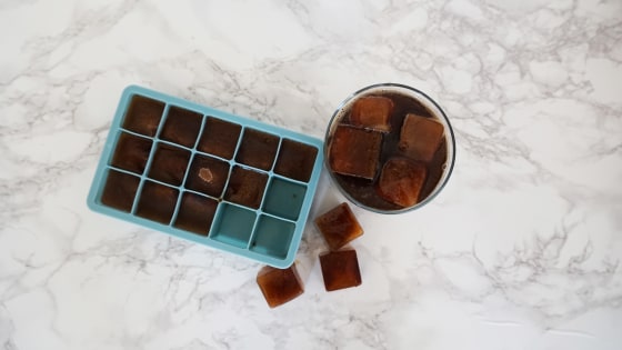 Pouring coffee in ice cube tray on grey background - Ducks 'n a Row