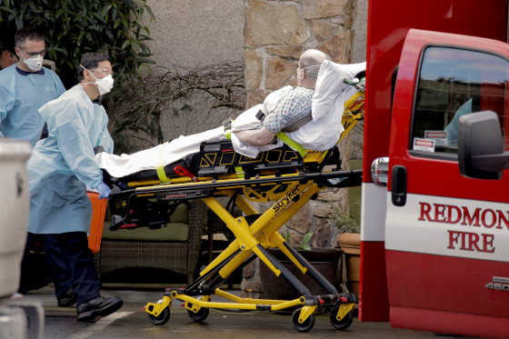 Image: Medics transport a man on a stretcher into an ambulance at the Life Care Center, a long-term care facility linked to several confirmed coronavirus cases, in Kirkland
