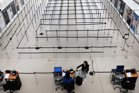 Image: People walk through an empty international departure terminal at John F. Kennedy Airport as concern over the coronavirus grow