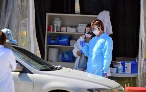 Medical workers at Kaiser Permanente French Campus test a patient for the novel coronavirus, COVID-19, at a drive-thru testing facility in San Francisco on March 12, 2020.