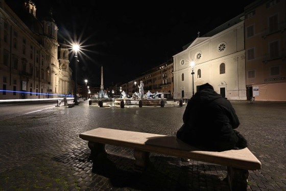 Image: A man sits on a bench at a deserted Piazza Navona in central Rome