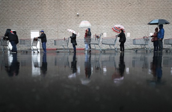Image: Shoppers wait in line in the rain to enter a Costco Wholesale store on March 14, 2020 in Glendale, California.