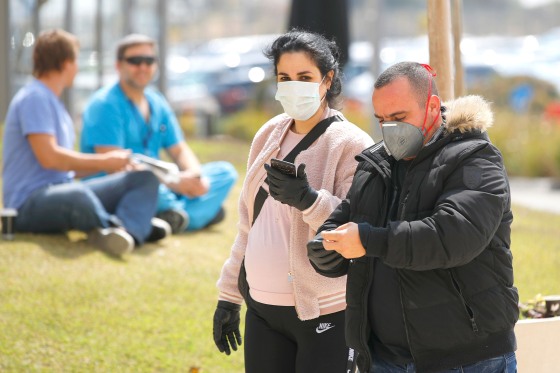 Image: People wearing protective masks walk into Samson Assuta Ashdod University Hospital on March 16, 2020 in the southern Israeli city of Ashdod, as the Jewish state introduces stringent measures to control the coronavirus pandemic.