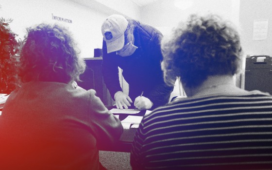 Image: Michael Grabowski checks-in to vote at a polling station in Illinois on March 17, 2020.