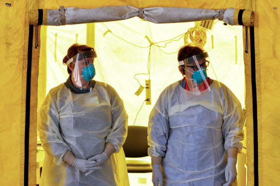Image: Hospital clinicians wait to test patients for coronavirus at a hospital in Newton, Mass., on March 18, 2020.