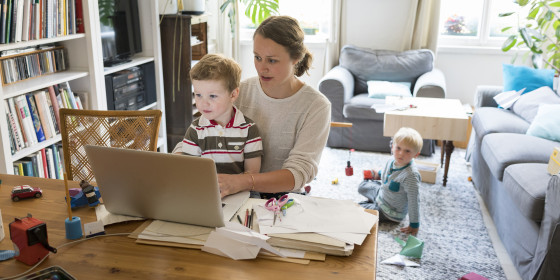 Female professional with two sons working at home