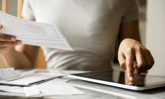 Image; Woman paying bills with digital tablet