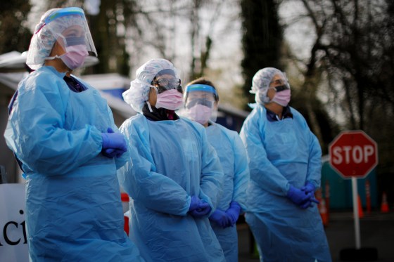 Image: Nurses wearing protective gear wait for patients at a drive-through coronavirus testing site in Seattle on March 17, 2020.