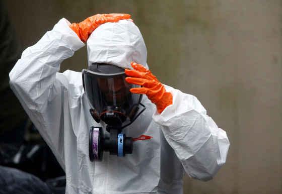 Image: A Servpro worker takes off protective gear after working on deep cleaning the Life Care Center of Kirkland,