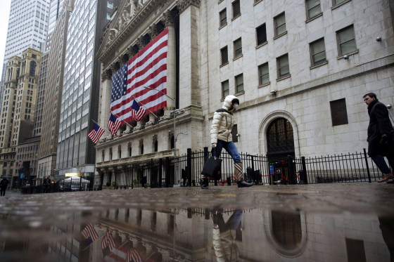 Image: A pedestrian wearing a masks walks past the New York Stock Exchange on March 19, 2020.