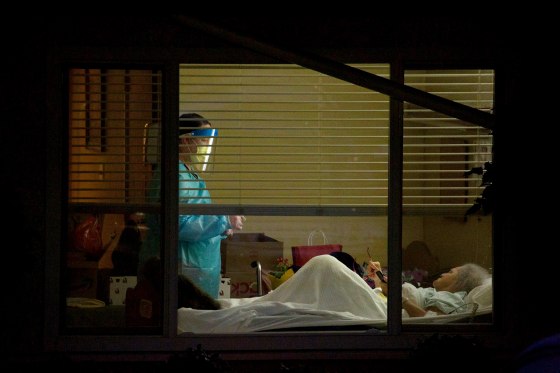 Image: A healthcare worker attends to Susan Hailey, who tested positive for coronavirus, at the Life Care Center of Kirkland in Washington state on March 13, 2020.