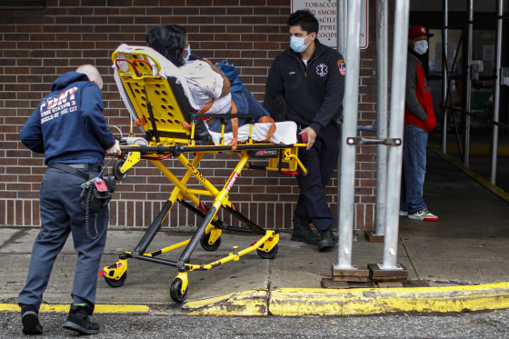 Emergency medical workers wear protective masks while delivering a patient to the emergency room at Brooklyn Hospital Center on Sunday.