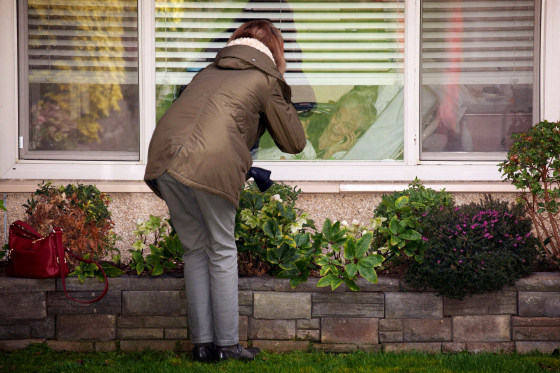 Image: Lori Spencer speaks to her mother, Judie Shape, through a window at the Life Care Center of Kirkland in Washington on March 8, 2020. The assisted living facility is linked to several confirmed coronavirus cases in the state.