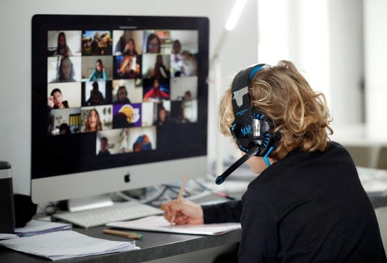 Image: A student takes classes online with his companions using the Zoom APP at home