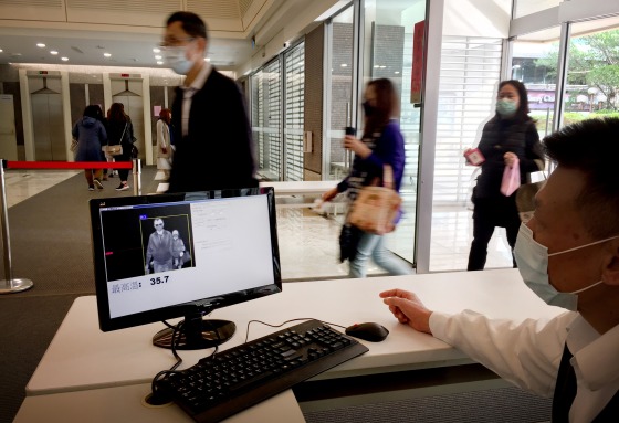 IMage: Managers and security guards in buildings throughout Taiwan now check the temperature of everyone walking in.