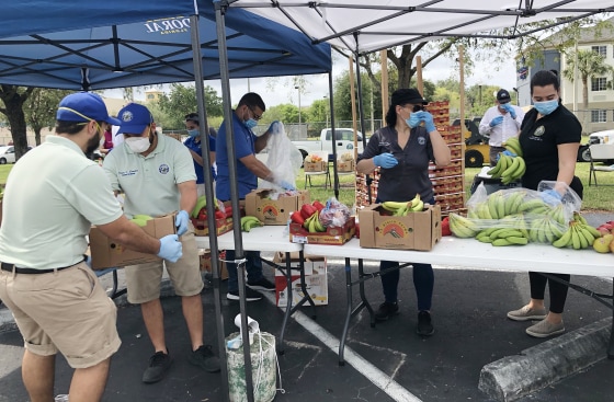 Volunteers distribute food at an event by Food Share in Doral, Fla.