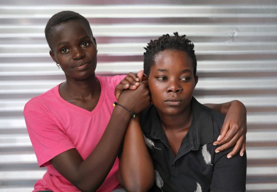 Image: Ugandan refugees Suzan Nakajiri and Eva Nabagala, both of the LGBT community, hold hands inside their shelter at the Kakuma refugee camp, in Turkana county