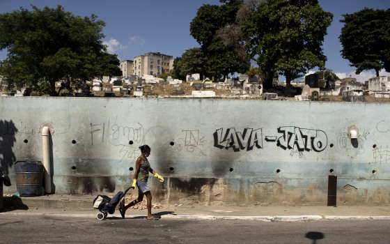 Image: A woman wearing a mask walks past Nossa Senhora das Gracas cemetery in Rio de Janeiro, Brazil, on April 27, 2020.
