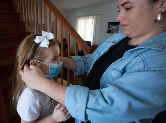Image: Tabata helps her daughter Naidelin, 5, to put on her face mask prior to going out in Santa Cruz on the Canary Island of Tenerife,
