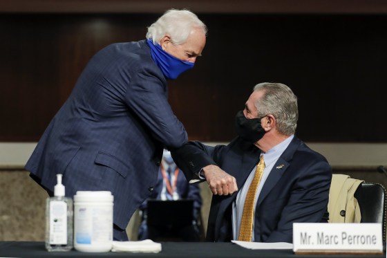 Image: Sen. John Cornyn, R-Texas, greets Marc Perrone, international president of the United Food and Commercial Workers International Union with an elbow bump, prior to the start of a Senate Judiciary Committee hearing