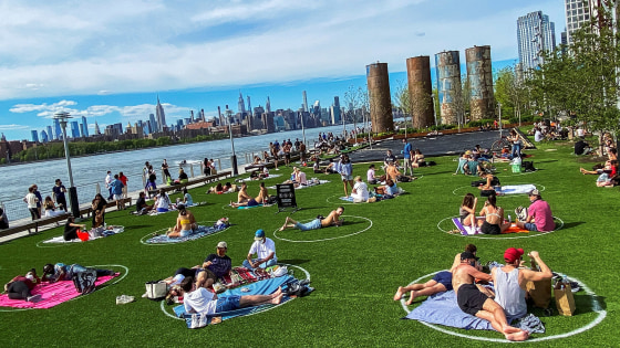Image: People try to keep social distance as they enjoy a warm day during the outbreak of the coronavirus disease (COVID-19) at Domino Park in Brooklyn, New York
