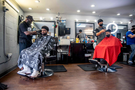 Image: Two men get their hair cut at a barbershop in Austin, Texas on May 8, 2020.