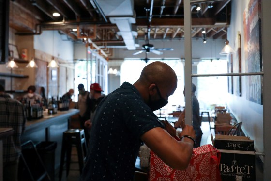 Image: Customers buy up stocks of wine, food and kitchen supplies as the restaurant Montmartre closes due to the coronavirus outbreak in Washington