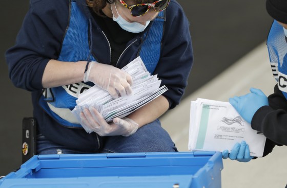 Election workers count ballots while collecting them from a drop box outside a voting center on April 28, 2020, in Windsor Mill, Md.