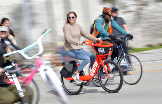 Image: A woman rides an Uber JUMP e-bike in Culver City, Calif.