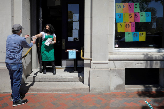Image: A customer picks up an order at a reopened Starbucks in Boston on May 20, 2020.