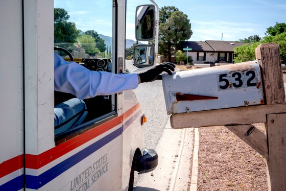 Image: A USPS mail carrier delivers mail in El Paso, Texas, on April 30, 2020.