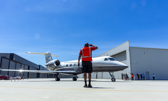 Image: A crew member salutes a Gulfstream IV jet carrying physicians on their way to New York from the Clay Lacy Aviation Terminal at Van Nuys Airport in Van Nuys, Calif., on April 23, 2020.