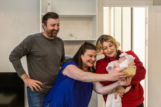 Image: Darlene Straub, 45, center, takes a selfie with Yulia, 33, left, a surrogate mother from Vinnytsia region holding Straub's newbron daughter Sophia, right, and her husband Chris Straub, 43, in Kyiv