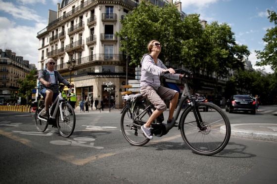 Image: A woman rides a bicycle as France eases lockdown measures on June 14, 2020.