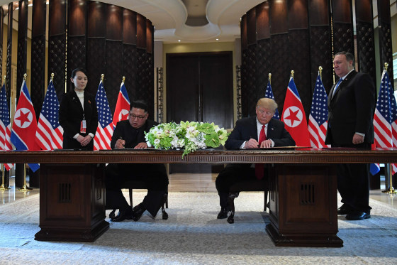 Image: President Donald Trump and North Korea's leader Kim Jong Un sign documents as Secretary of State Mike Pompeo and the North Korean leader's sister Kim Yo Jong look on