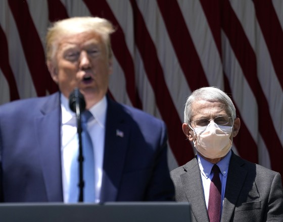 Image: President Donald Trump is flanked by Dr. Anthony Fauci while speaking about coronavirus vaccine development in the Rose Garden of the White House.