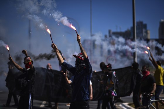 Demonstrators hold flares during a protest against racism, the policies of President Jair Bolsonaro's government, and to defend democracy amid the coronavirus pandemic in Brasilia, Brazil on Sunday.