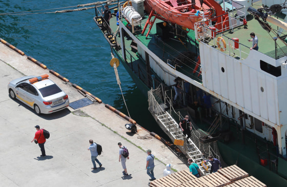 Image: Sixteen crewmen, who have tested positive for the coronavirus, disembark from a Russian refrigerator ship at Gamcheon Port in Busan, South Korea