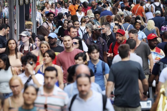 Image: People walk through New York's Times Square.