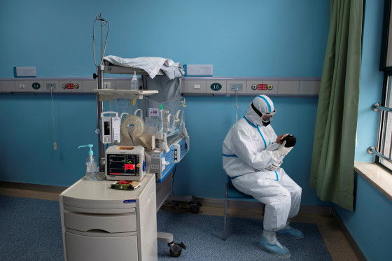 Image: Nurse in protective suit attends to a baby with COVID-19, caused by the coronavirus, at an isolation ward of Wuhan Children's Hospital in Wuhan