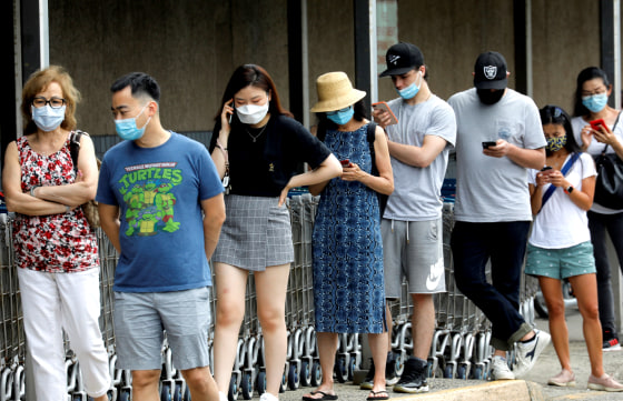 Image: People wear protective face masks outside at a shopping plaza in Edgewater, New Jersey