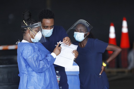 Image: Healthcare workers meet at a COVID-19 drive-thru testing site in St. Petersburg, Fla.