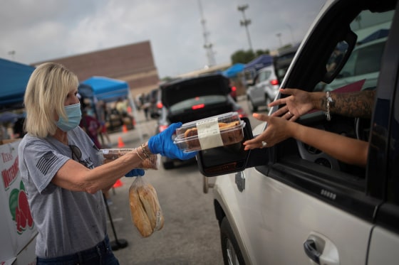 Image: Volunteer give food to residents economically affected by COVID 19 pandemic during San Antonio Food Bank distribution in Texas