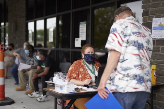 One-stop operator Vickie Gregorio with the Heartland Workforce Solutions talks to a jobseeker outside the workforce office in Omaha, Neb., on July 15, 2020.