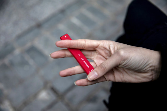 A woman holds a Puff Bar flavored disposable vape device in New York on Jan. 31, 2020.