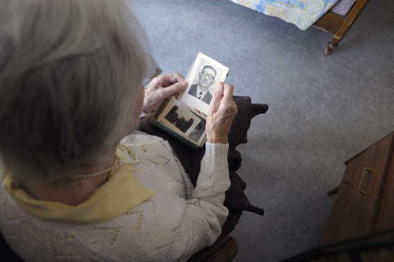 A woman suffering from Alzheimer's disease looks at an old picture in a retirement house in Angervilliers, eastern France, on March 18, 2011.